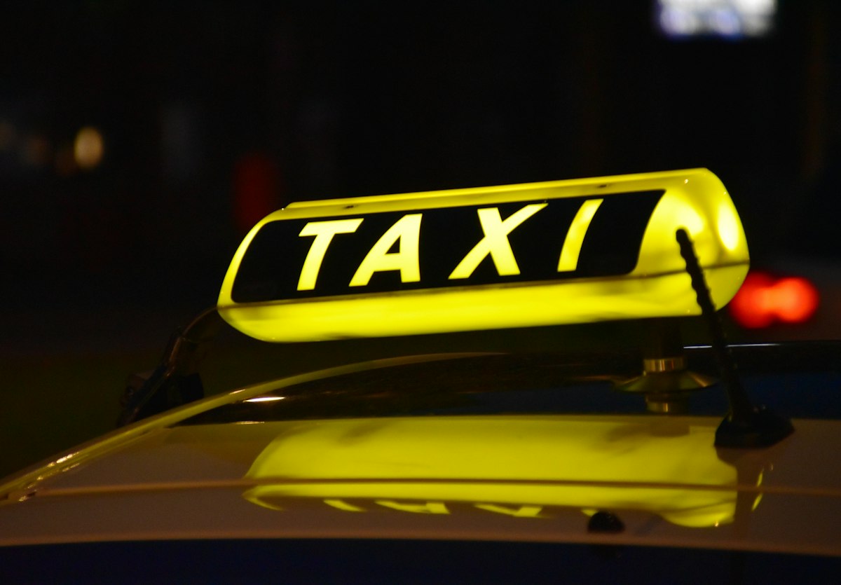 Illuminated taxi rooftop advertising sign at night